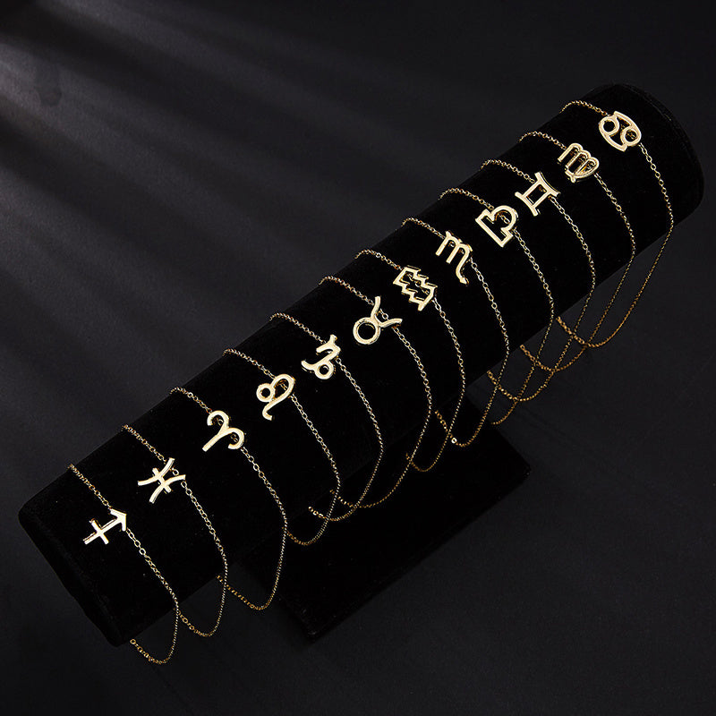 Set of gold bracelets with zodiac symbols on a black background