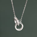 Silver necklace with interlocking rings pendant on a dark green background