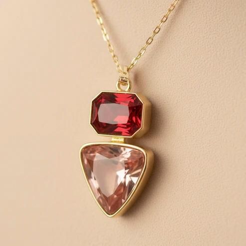 Necklace with a red and pink gemstone pendant on a beige background